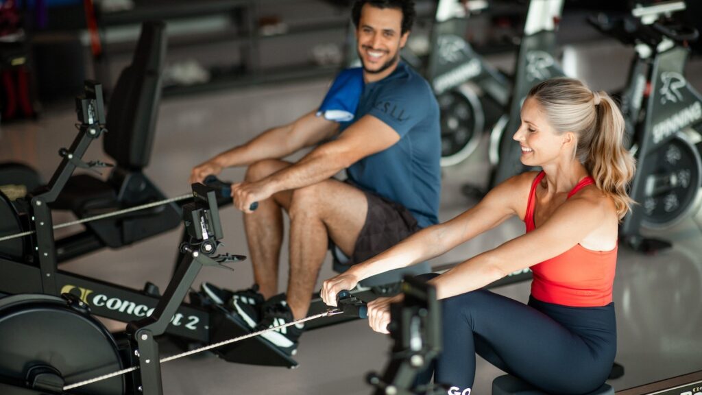 mies ja nainen soutavat soutulaitteilla