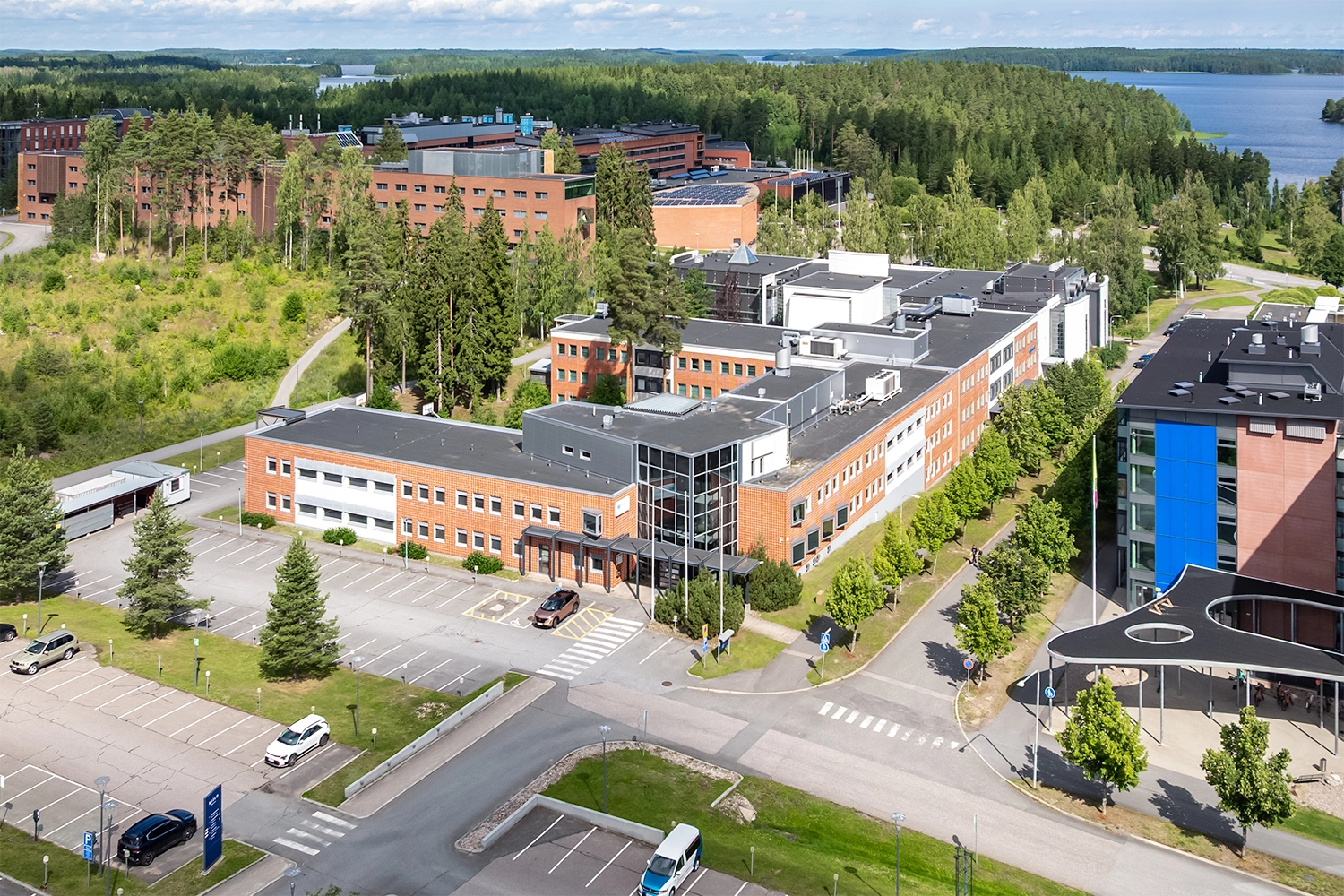 Kielo Lappeenranta – Laserkatu 8 toimitilakiinteistö, jossa punatiilinen julkisivu. Rakennuksen edessä parkkipaikkoja.