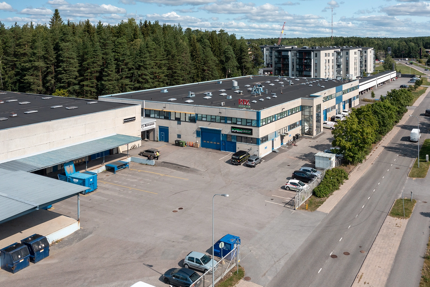 Lukkocenter ilmakuvassa. Kahdesta beigestä laatikkomaisesta rakennusosasta koostuvaa kiinteistöä ympäröi suuri pysäköintialue.