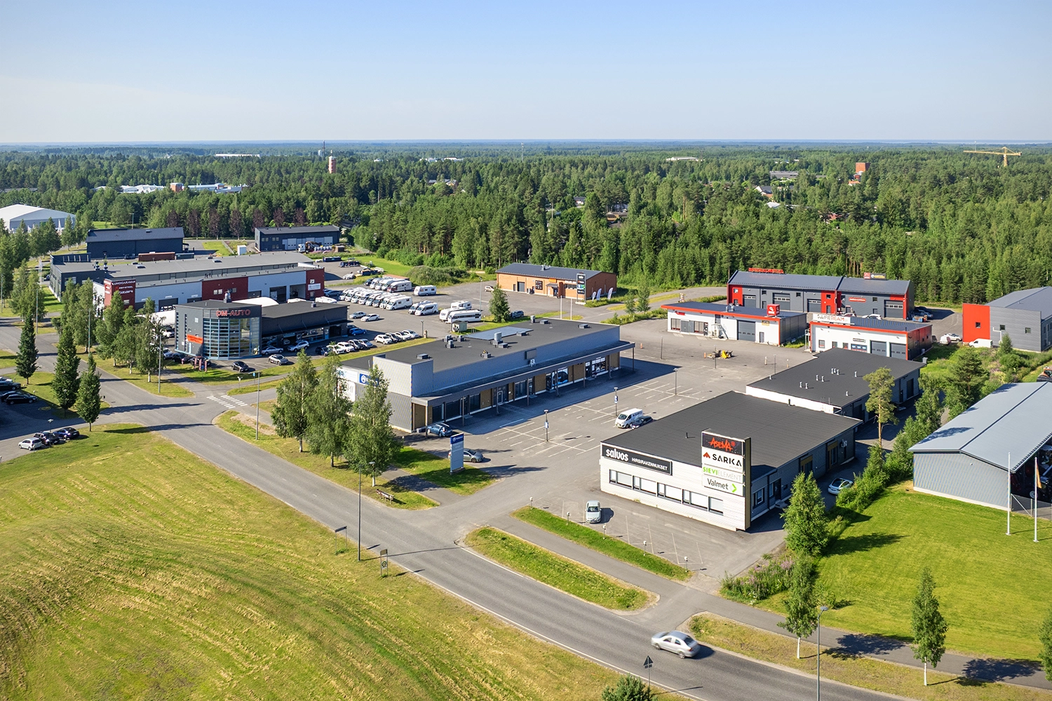 Ilmakuva toimitilakiinteistö Kempeleen Zatelliittintie 17:sta. Kiinteistö sijaitsee teollisuusalueella, etualalla autotie ja kiinteistöjen edustalla parkkipaikat. 