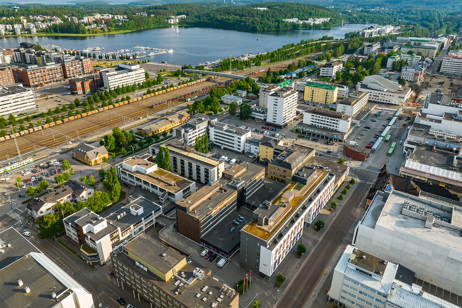 Jyväskylän Vapaudenkatu 48-50 ilmakuvassa. Taustalla ratapiha ja järvimaisema.