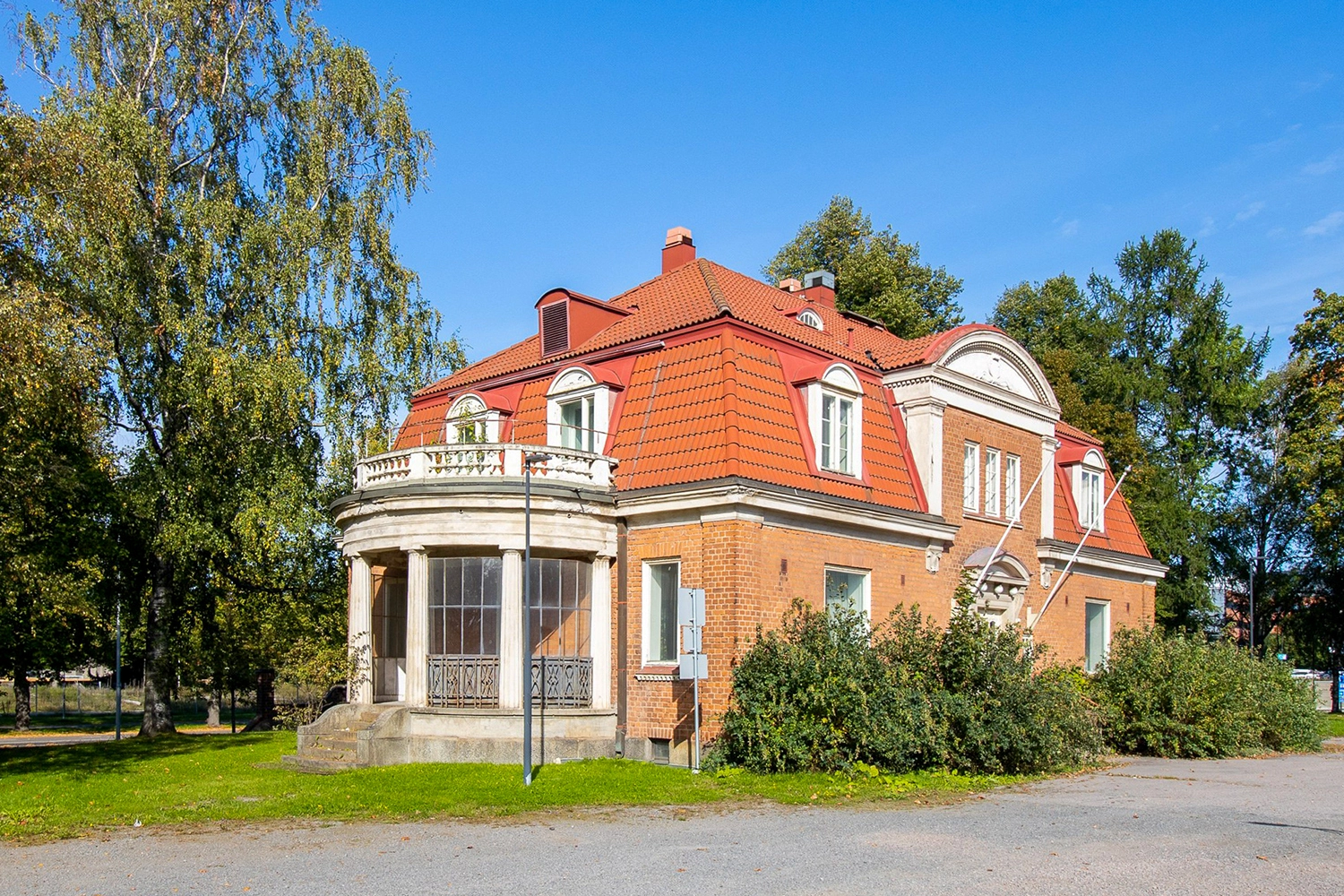 Konsulitalo 36Hatanpään pihapiirissä. Vanhassa ja tyylikkäässä tiilitalossa on punainen mansardikatto sekä päädyssä pyöreä lasipaviljonki.